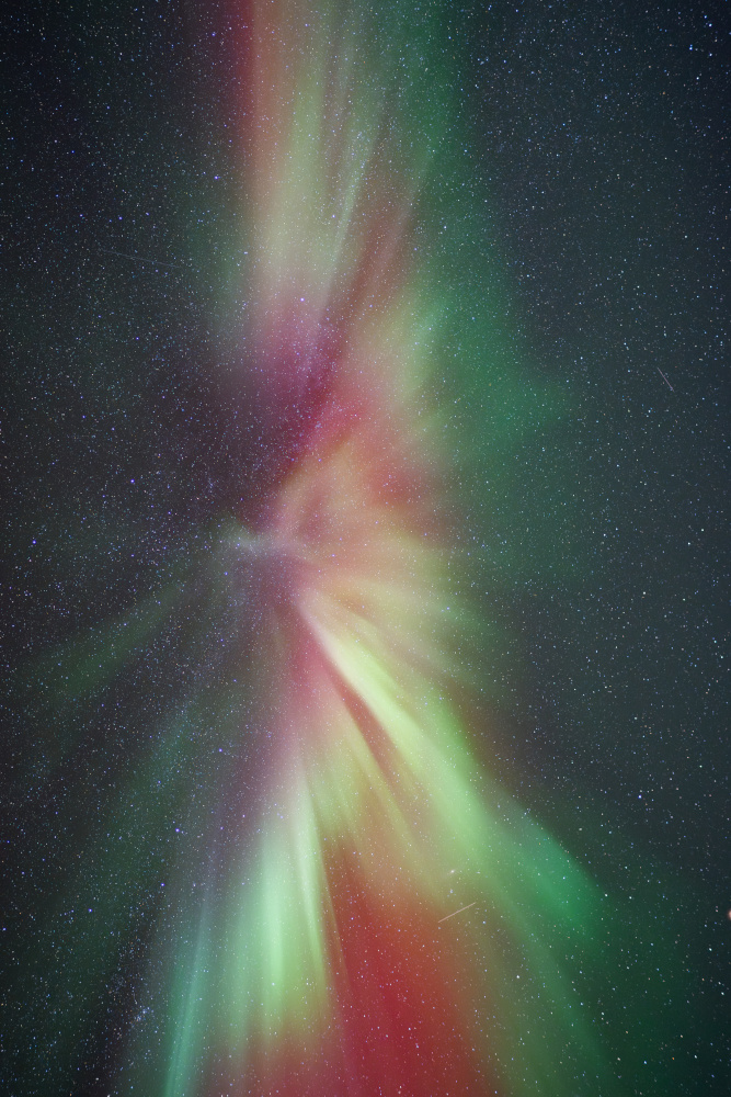 Aurora boreal amb corona difusa, estrelles i colors vermells i verds. Abisko, Lapònia sueca.