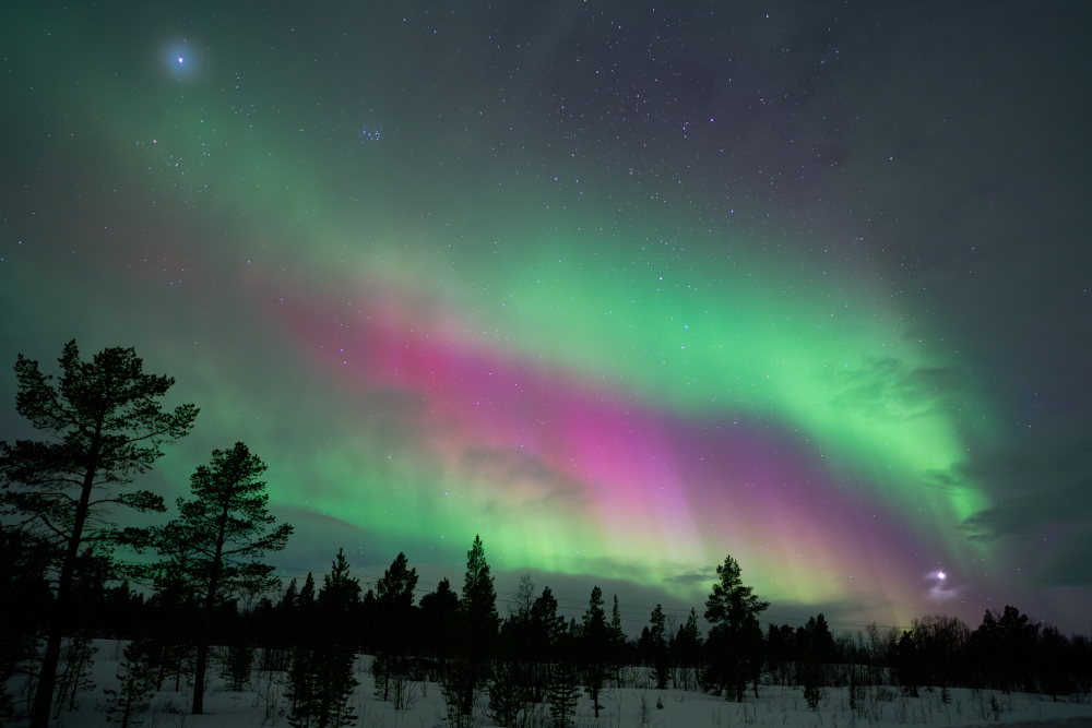 Aurora boreal en tres franges horitzontals de color verd, rosa i verd, a Kiruna, Suècia.