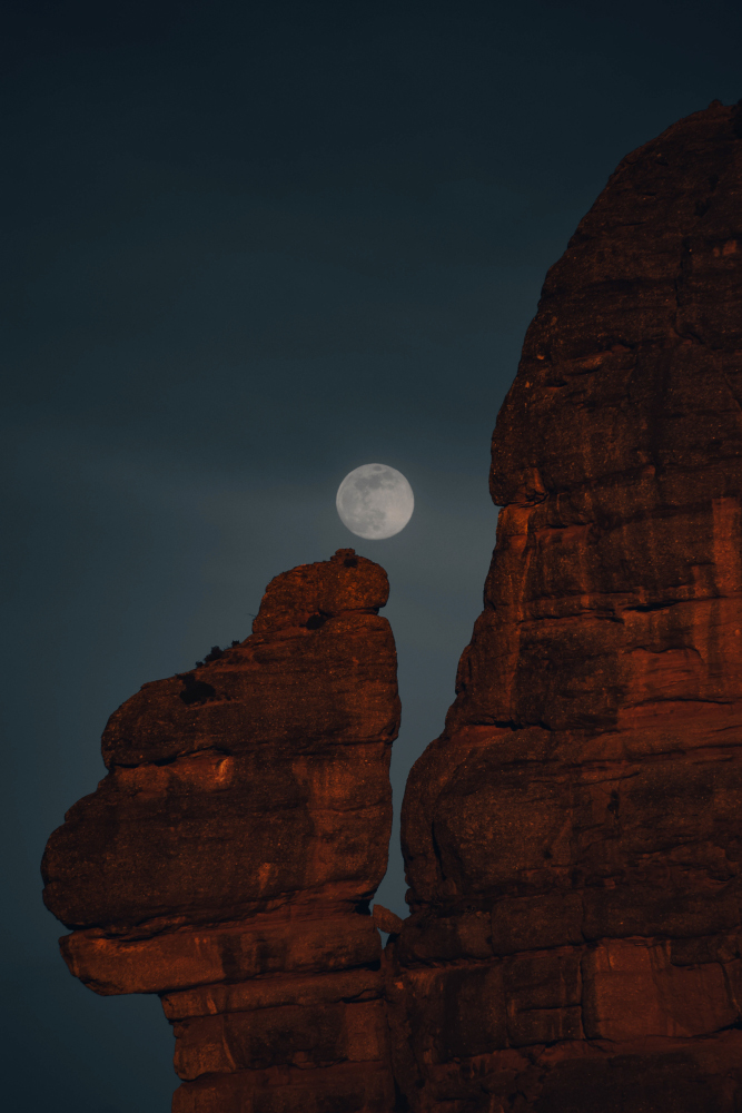 Lluna plena sortint per la roca foradada de la muntanya de Montserrat.