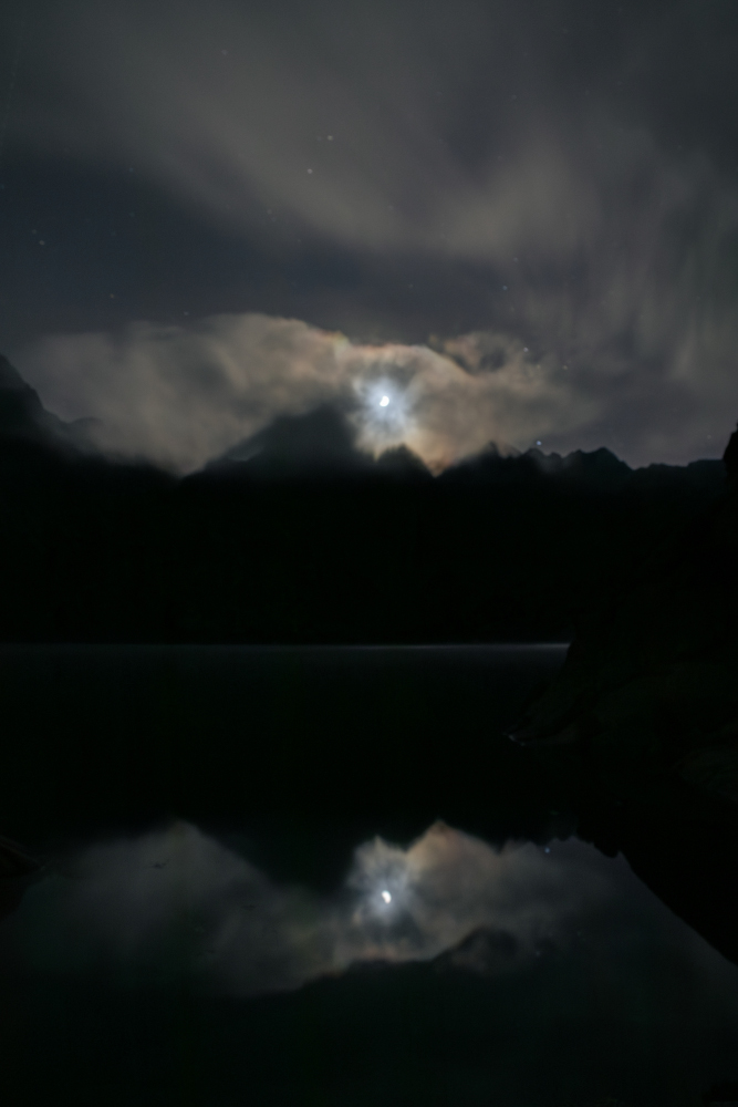 Reflexe de la lluna i d'una muntanya a l'estany negre del Pirineu.