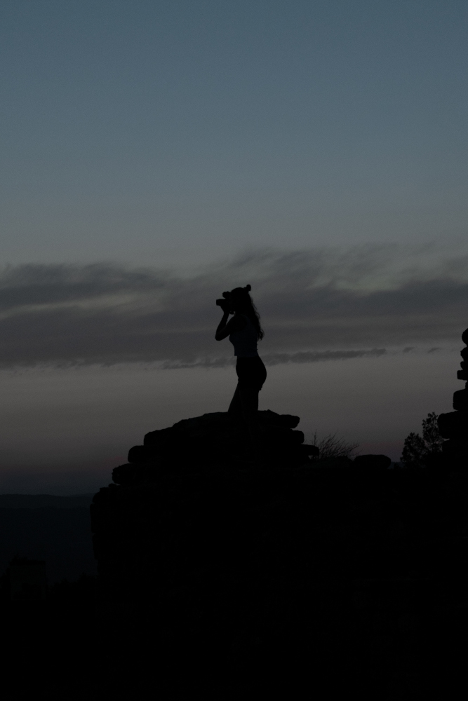 Silueta d’una noia fotografiant el cel nocturn a Montserrat.